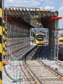 Vario 353 projíždí zastřešeným úsekem provizorní trati 15. 6. 2017