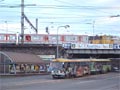 Pražská souprava metra vyrobená v Mitiščinském strojírenském závodě po omlazovací kůře ve Škodě dopravní technice spolu s  bývalou mosteckou soupravou tramvaí T3 u plzeňského nádraží 18. 12. 2004
 